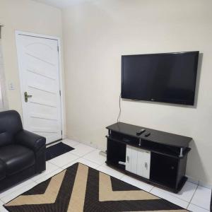 a living room with a flat screen tv on a wall at Casa Recanto de Unamar in Cabo Frio