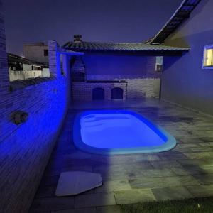 a large blue swimming pool in a backyard at night at Casa Recanto de Unamar in Cabo Frio