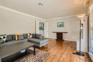 a living room with a couch and a table at Elegant 3BR Bungalow Oasis plus Pool in Prime Locations in Houston