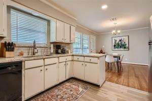 a kitchen with white cabinets and a dining room at Elegant 3BR Bungalow Oasis plus Pool in Prime Locations in Houston