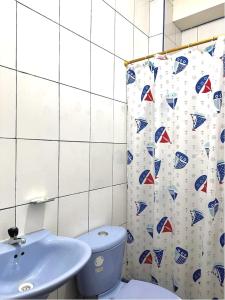 a bathroom with a toilet and a shower curtain at Hotel Zulema Inn in Esmeraldas