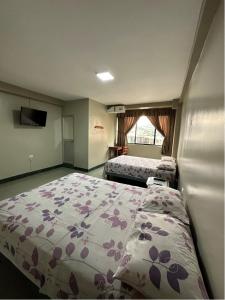 a hotel room with two beds and a window at Hotel Zulema Inn in Esmeraldas
