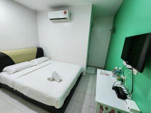 Habitación pequeña con cama y TV de pantalla plana. en Minshu RoomStay, en Arau