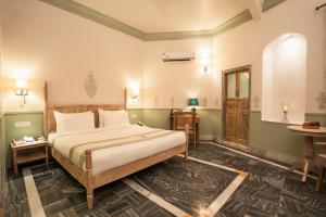 a bedroom with a large bed in a room at Dev Mahal - A Boutique Heritage Hotel in Jaipur