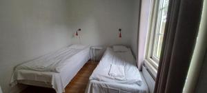 2 camas en una habitación con ventana en Mellbystrand Vandrarhem & Stugor Solstickan, en Mellbystrand
