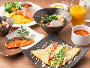 uma mesa coberta com pratos de alimentos e bebidas em Villa Fontaine Grand Haneda Airport em Tóquio