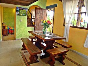 a wooden table with benches and a vase of flowers on it at Villa Salomé Apartamentos Turísticos in Duitama