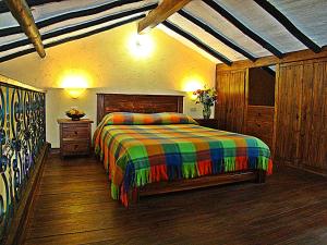 a bedroom with a bed with a colorful blanket at Villa Salomé Apartamentos Turísticos in Duitama +22 photos