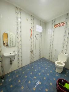 a bathroom with a toilet and a sink at Villa Benny Gsp Cipanas in Cibadak