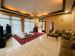 a living room with a couch and a tv at Villa Benny Gsp Cipanas in Cibadak