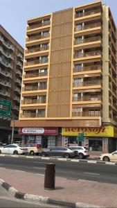 a large building with cars parked in front of it at Dubai NorthStar Hostels in Dubai