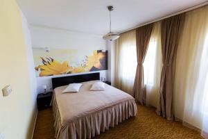 a bedroom with a bed and a painting on the wall at Hotel Grandis Apulum in Mioveni +37 photos