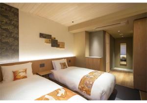 a hotel room with two beds in a room at Hotel Legasta Kyoto Higashiyama Sanjo in Kyoto