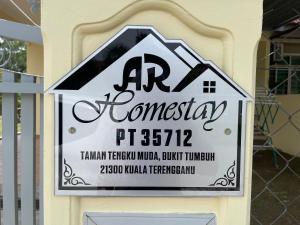 um sinal para uma casa na parede em AR HOMESTAY KUALA TERENGGANU em Kuala Terengganu