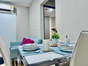 stół jadalny z talerzami i świecami w obiekcie 2 Bedroom Nice Location @ BTS onnut w mieście Bang Chak