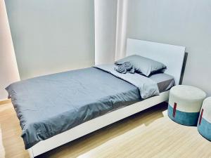 a bedroom with a bed with a blue comforter at 2 Bedroom Nice Location @ BTS onnut in Bang Chak
