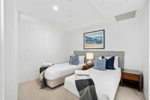 a bedroom with two beds and a couch at Oracle Resort Broadbeach - GCLR in Gold Coast
