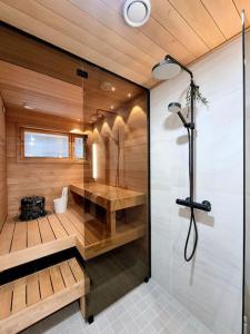 een grote badkamer met een douche en een glazen deur bij Holiday Black Pearl in Rovaniemi