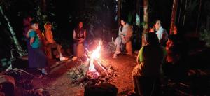 een groep mensen die rond een vuur zitten bij 7 Heaven Resorts in Ambalavayal