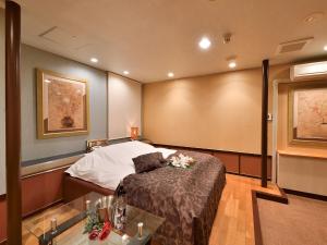 a hotel room with a bed and a table at Restay DEE (Adult Only) in Tokushima