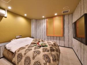 Un dormitorio con una cama con flores. en Restay DEE (Adult Only) en Tokushima