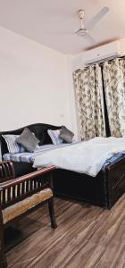 sypialnia z łóżkiem i ławką w obiekcie Family 3bhk Home stay! w Nowym Delhi