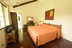 een slaapkamer met een bed met een oranje sprei bij Eden Nature Park and Resort in Davao City