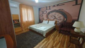a bedroom with a bed and a large clock on the wall at Guest rooms KRASI in Strazha