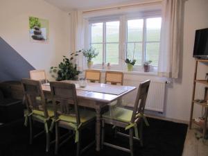 comedor con mesa, sillas y ventana en Ferienwohnung Hägelhof en Naila