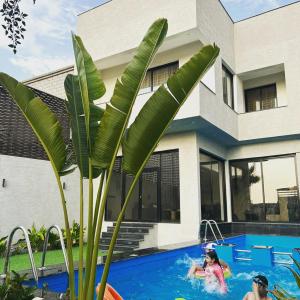 two people in a swimming pool in a house at شاليه بلاك وايت in Al Harazat