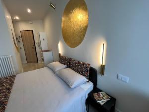 um quarto com uma cama branca e uma esfera dourada na parede em Jonis Parco Ruffini em Turim