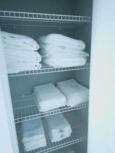 a closet filled with lots of white folded towels at Spacious Modern 4bd 2ba Home! Close to LEGOLAND in Winter Haven