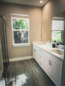 a bathroom with two sinks and a window at Spacious Modern 4bd 2ba Home! Close to LEGOLAND in Winter Haven