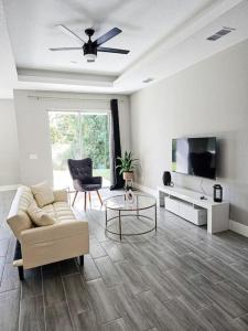 uma sala de estar com um sofá e uma televisão em Spacious Modern 4bd 2ba Home! Close to LEGOLAND em Winter Haven