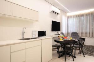 a kitchen and dining room with a table and chairs at Cozy Apartment in the Heart of Tel Aviv Sea N' Rent in Tel Aviv