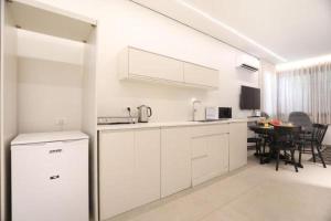 a kitchen with white cabinets and a table in it at Cozy Apartment in the Heart of Tel Aviv Sea N' Rent in Tel Aviv