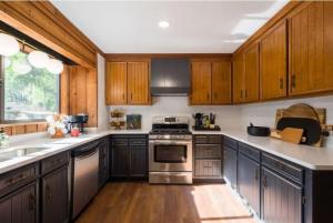 a kitchen with wooden cabinets and stainless steel appliances at Hammock Trail Lake - Lake Park - Valdosta Area in Lake Park