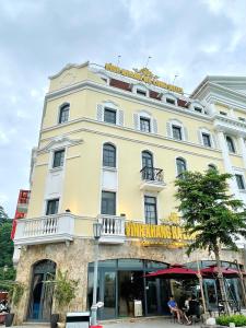 un grande edificio giallo con un balcone sopra di VĨNH KHANG HẠ LONG HOTEL a Ha Long