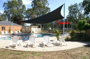 um grupo de cadeiras brancas e uma piscina em Cohuna Waterfront Holiday Park em Cohuna