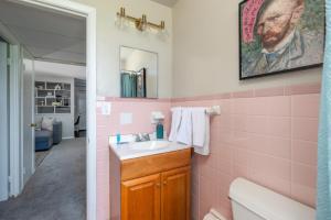 a pink bathroom with a sink and a mirror at Maple Heights Gem Libby Unit 1 in Maple Heights +35 photos