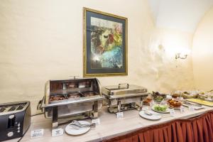 a buffet with trays of food on a table at Rija Domus Hotel in Rīga