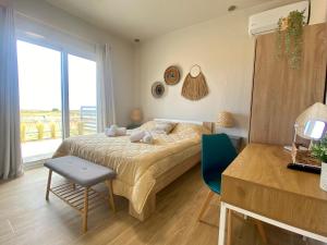 ein Schlafzimmer mit einem Bett und einem großen Fenster in der Unterkunft Boho Vibes Beachfront Detached House in Análipsis