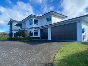 une grande maison blanche avec un grand garage dans l'établissement Punawai Homestay, à Taupo