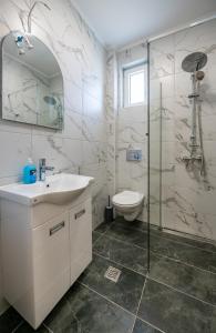 La salle de bains est pourvue d'un lavabo, d'une douche et de toilettes. dans l'établissement M&A Apartmani, à Vrdnik