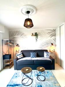 a living room with a blue couch and two tables at Studio DUNES de NALA avec balcon vue Dunes et latérale Mer pour 4 pers 100m plage wifi ménage compris in Fort-Mahon-Plage