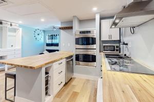 a kitchen with white cabinets and a wooden counter top at Linden Way Studio in La Mesa