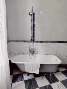 a bath tub in a bathroom with a shower at B&B "La Bottega d'Arte" in Carrara