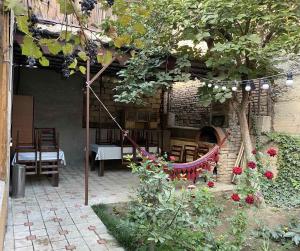 Un patio con mesa y sillas y flores. en Family Apartments "IGWT", en Tiflis