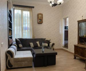 een woonkamer met een bank en een salontafel bij Family Apartments "IGWT" in Tbilisi City