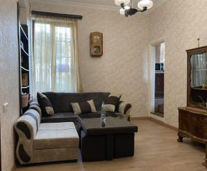 Una sala de estar con un sofá y una mesa de café. en Family Apartments "IGWT", en Tiflis